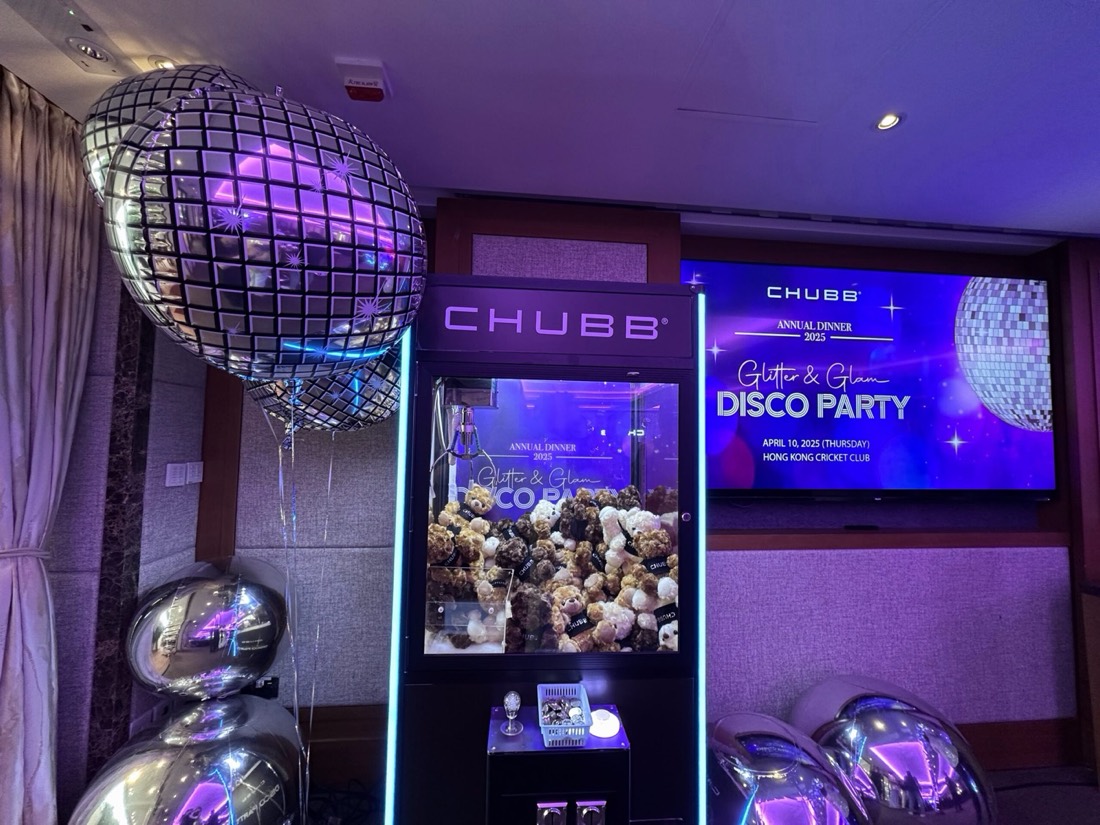 酒店宴會廳內的公司周年晚宴,訂製品牌夾公仔機放在舞台旁,機內載滿毛公仔